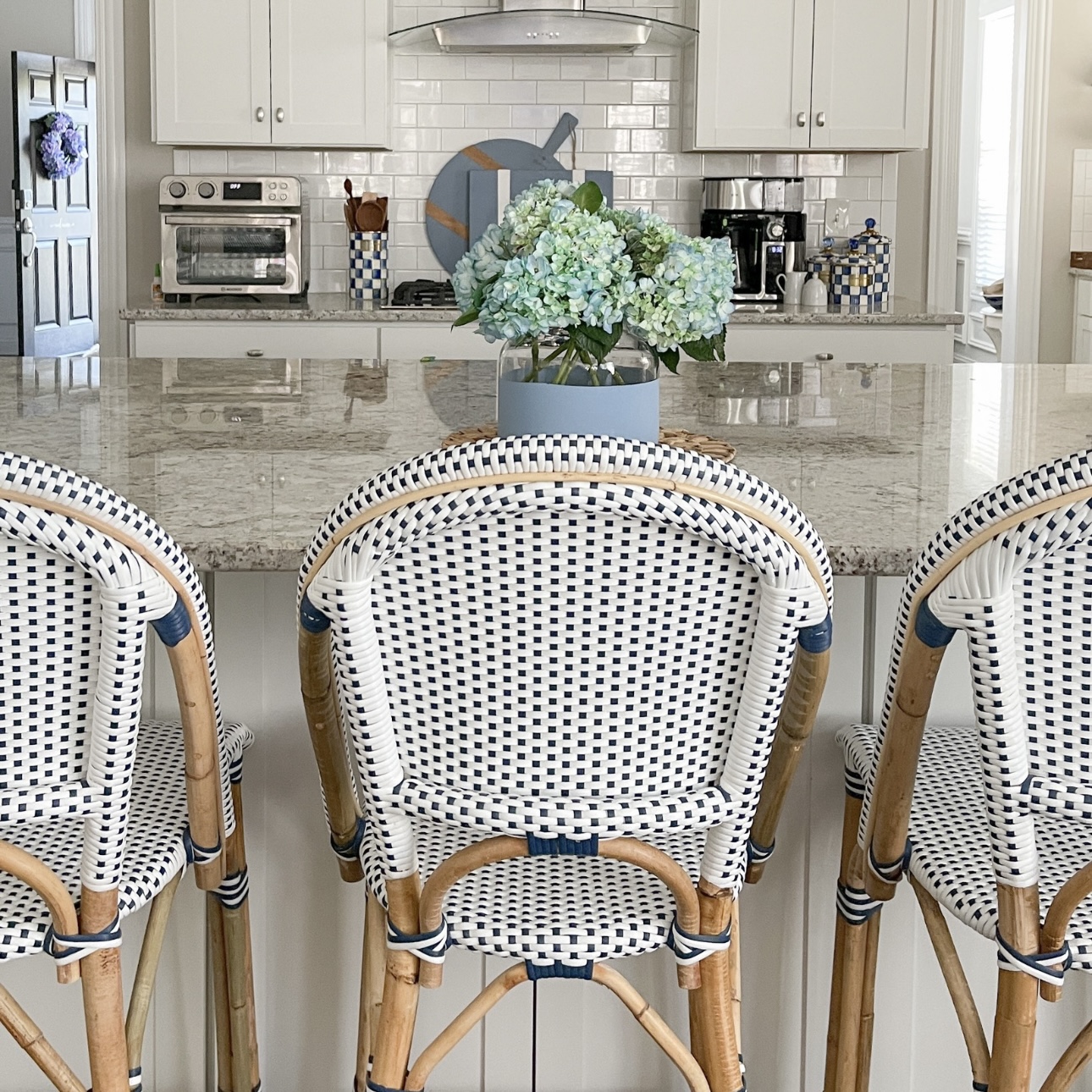 Rattan kitchen chairs warm up an all white kitchen