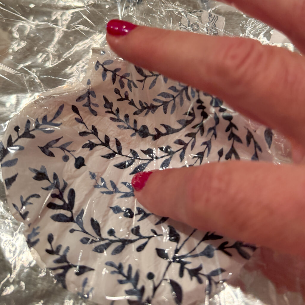 use saran wrap tpo gentkly rub the napkin to the shell without tearing it 